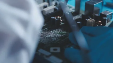 Closeup of a gloved hand installing a microchip on a blue motherboard. Perf.. Stock Footage 341547329