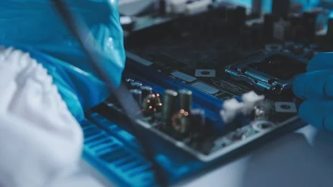 Closeup of a gloved hand installing a microchip on a blue motherboard. Perf.. Stock Footage 341547330