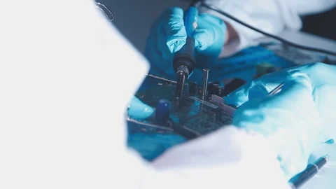 Closeup of a gloved hand installing a microchip on a blue motherboard. Perf.. Stock Footage 341547448