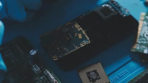 Closeup of a gloved hand installing a microchip on a blue motherboard. Perf.. Stock Footage 341547686