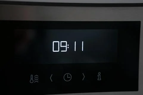 Closeup of glowing white numbers on the timer of a microwave Stock Photos