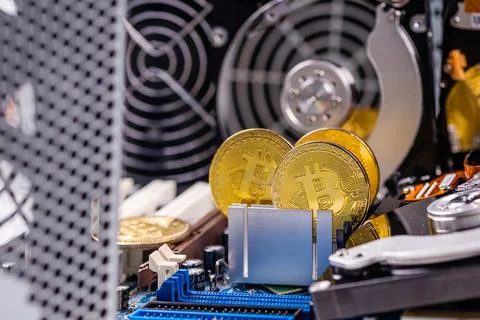 Closeup of gold bitcoin on computer components background, technology and dig Stock Photos