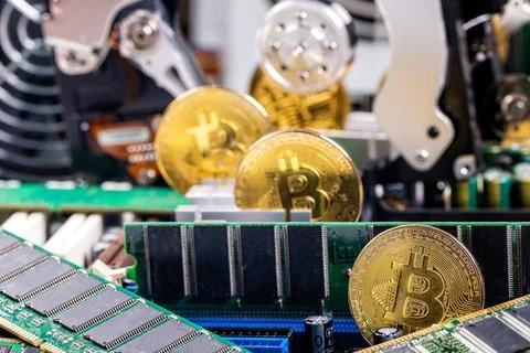 Closeup of gold bitcoin on computer components background, technology and dig Stock Photos