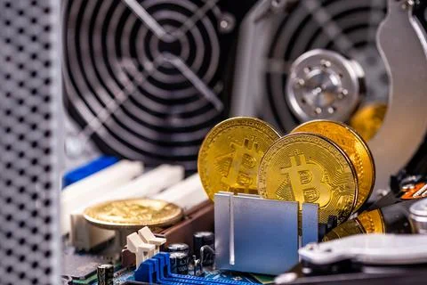 Closeup of gold bitcoin on computer components background, technology and dig Stock Photos