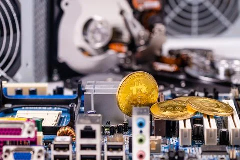 Closeup of gold bitcoin on computer components background, technology and dig Stock Photos