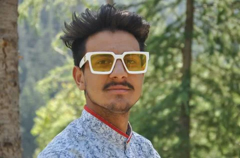 Closeup of a good looking young guy standing outdoor in the nature Stock Photos
