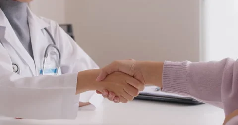 Closeup GP warm welcome talk to patient shaking hand at office Stock Footage 196801869