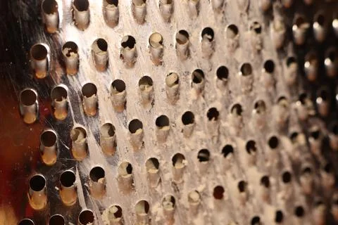This is a CloseUp of a Grater Surface featuring multiple holes that serve a Stock Photos