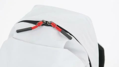 Closeup gray backpack bag with red zipper lock rotates on white background, 4K Stock Footage 197144200