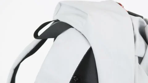 Closeup gray backpack bag with red zipper lock rotates on white background, 4K Stock Footage 201062270