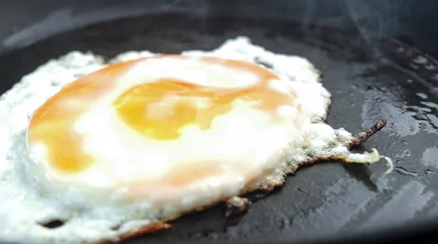 Closeup of greasy fried egg on frying pan with cooking audio Stock Footage 44889343