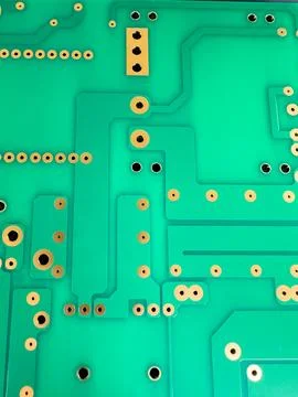 Closeup of a green circuit board with multiple holes Stock Photos