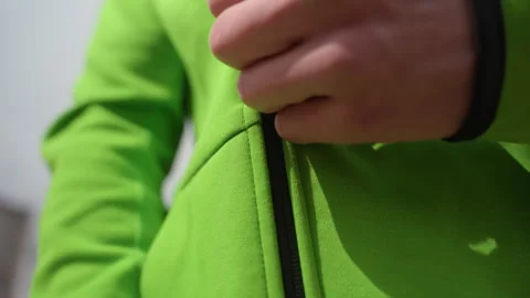 Closeup green jacket fabric and zipper, vivid outerwear texture and seam detail Stock Footage 330610064