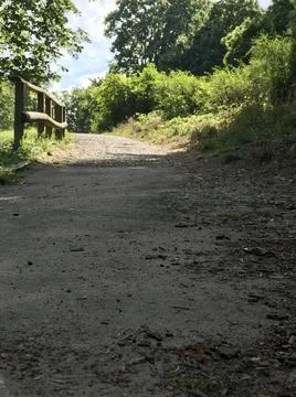 Closeup ground perspective of facing a pathway uphill with stone pieces caused b Stock Photos