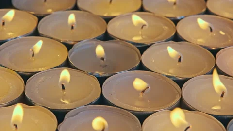 Closeup of a group of burning tea lights with warm orange yellow flames Stock Footage 219579128