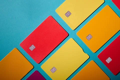 Closeup of a group of multicolored microchip debit cards on a blue table. Stock Photos