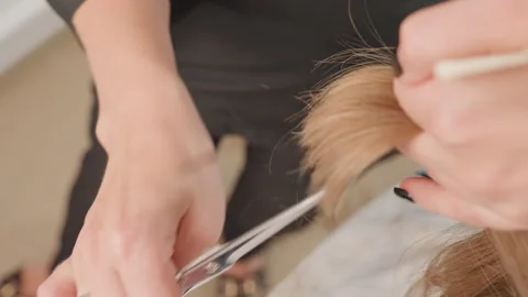Closeup of hairstylist expertly removing split ends skillfully, Precise hair Stock Footage 333654062