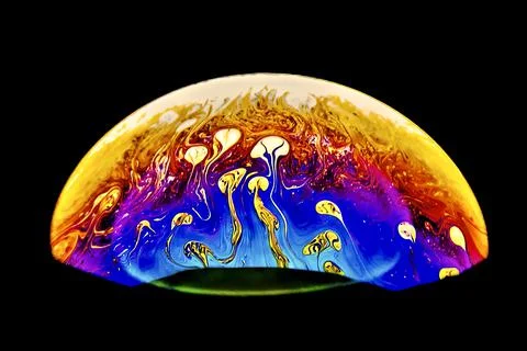 Closeup of half bubble with abstract patterns on a dark background Stock Photos