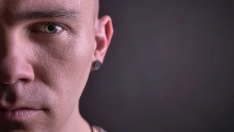 Closeup half-face portrait of handsome caucasian man looking straight at camera Video stock 100294252