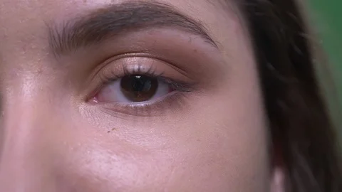 Closeup half face portrait of young pretty caucasian female with brown eyes and Stock Footage 108662364