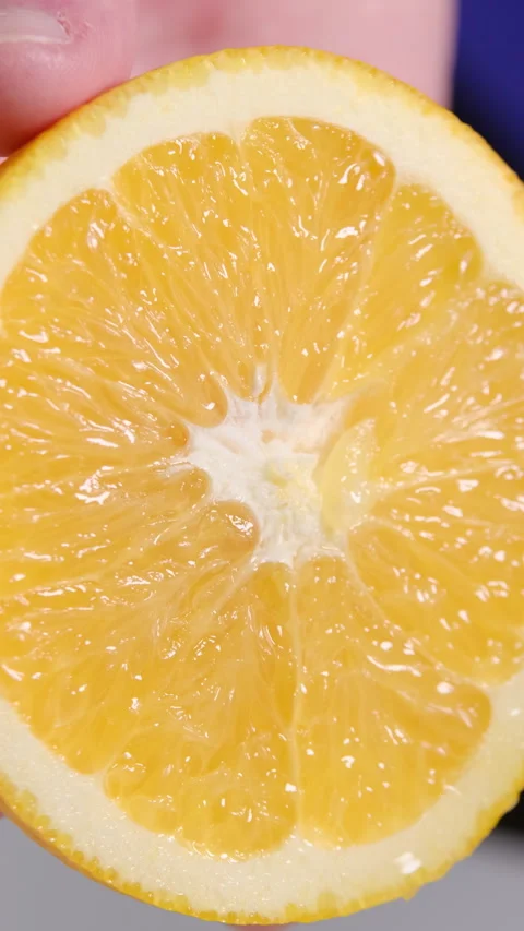Closeup of a Halved Orange Held by Hand Stock Footage 302507245