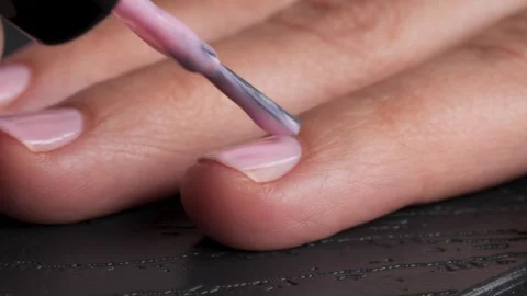 Closeup of hand applying pink nail polish with precision and care Vidéo 293630787