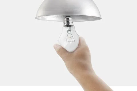 Closeup hand changing an electric light bulb Stock Photos