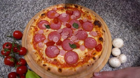 Closeup hand of chef baker in uniform blue apron cutting pizza at kitchen Stock Footage 135313174