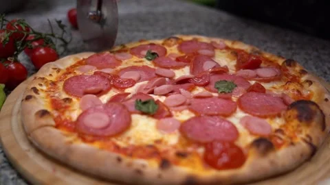 Closeup hand of chef baker in uniform blue apron cutting pizza at kitchen Video stock 135313331