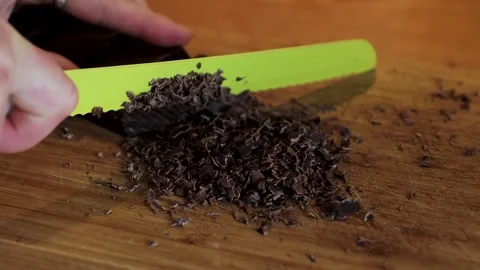 Closeup of a hand cutting a dark chocolate bar into small pieces with a kni.. Stock Footage 340897458