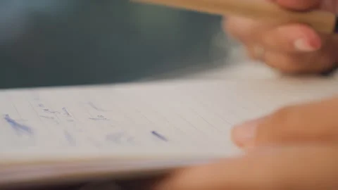 Closeup hand editing handwritten notes, pen hovering over lined page, manuscript Stock Footage 330165967