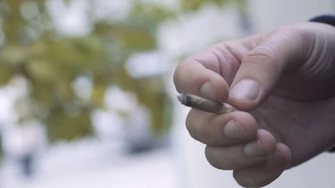 Closeup hand of a freaky man with a cigarette outdoor Stock-Footage 81500344