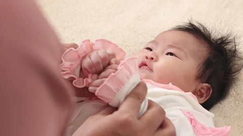 Closeup hand hold tiny hand play together, 3 months toddler infant feel saf.. Stock Footage 249810489