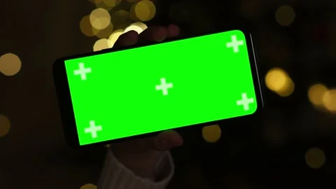 Closeup hand holding Chroma Key Green Screen in horizontal position in dark Video stock 221662365