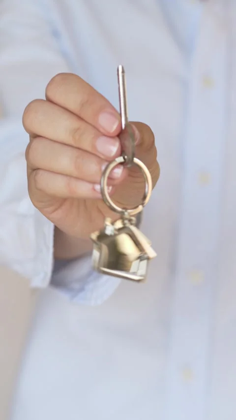 Closeup of hand holding keys with house keychain in premium real estate 動画素材 336381225