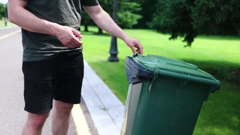Closeup hand holding piece of garbage in trash can, man throws garbage Stock Footage 337188451