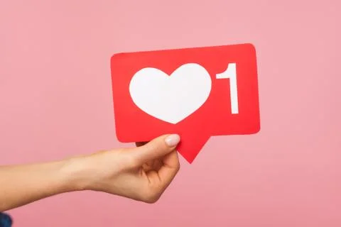 Closeup of hand holding social media heart like icon with number one, recomme Stock Photos