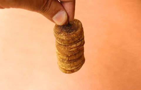 Closeup of a hand holding a stack of dry figs Stock Photos