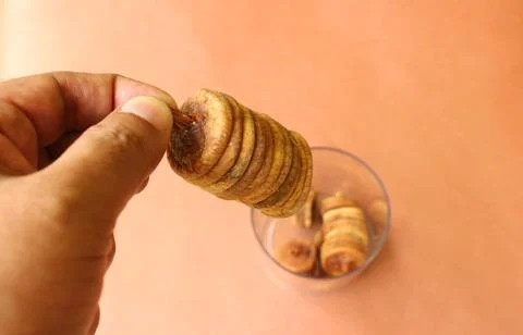 Closeup of a hand holding a stack of dry figs Stock Photos