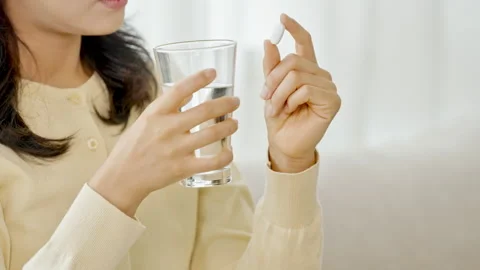 Closeup of Hand Holding Supplement Capsule Against Bright Background Stock Footage 339516083