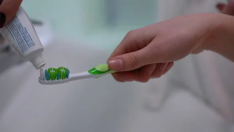 Closeup of a hand holding a tooth paste loaded tooth brush Stock Footage 295422918
