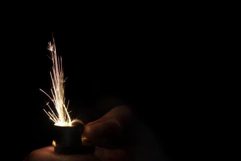Closeup to hand igniting fire lighters with black background. 写真素材