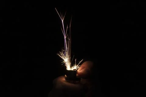 Closeup to hand igniting fire lighters with black background Stock-Fotos