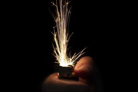 Closeup to hand igniting fire lighters with black background. Foto stock
