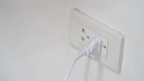 Closeup of hand inserting an electrical plug into a wall socket. Stock Footage 155729219