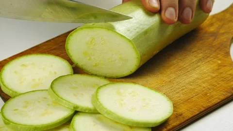 The closeup hand with a knife cuts the squash on a wooden Board. Stock-Footage 131070860