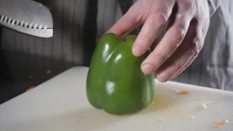 Closeup of hand with knife cutting fresh vegetable. Young chef cutting paprika Stock Footage 84784735