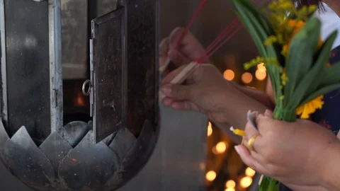Closeup hand light the incense stick with people praying in temple Video stock 125194285