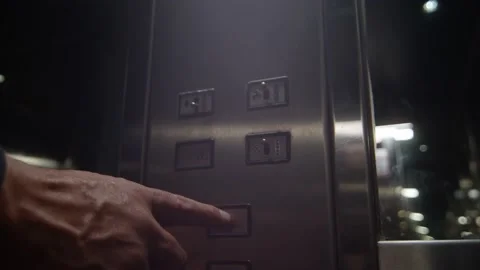 Closeup of the hand of a man inside a metallic elevator pressing the Stockbeeldmateriaal 221784726