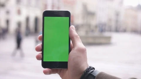 Closeup hand of man touching vertical green screen phone on the streets Stock Footage 78566577